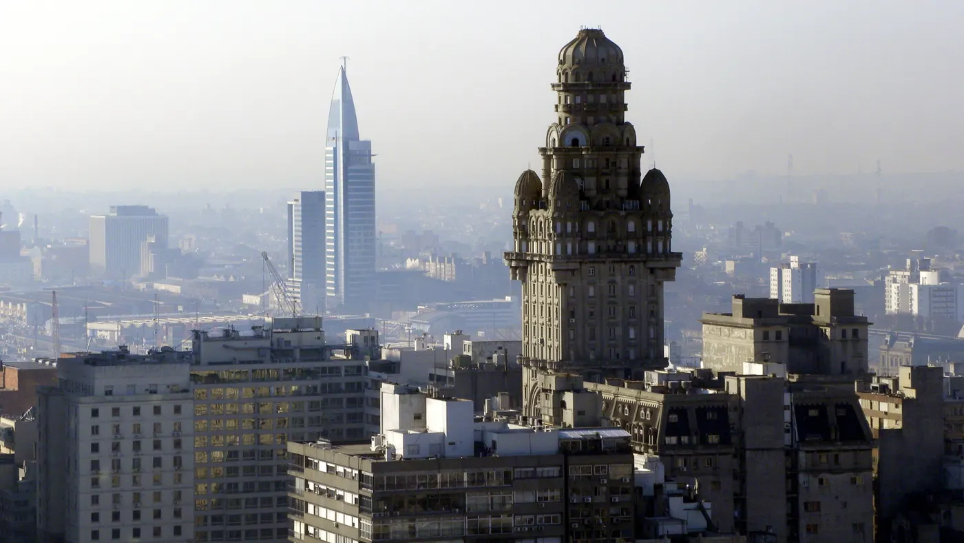 O Pal&aacute;cio Salvo e a torre de telecomunica&ccedil;&otilde;es da Antel sobre os telhados de Montevid&eacute;u, sob uma n&eacute;voa suave da manh&atilde;