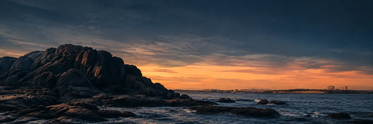 Recreación de una costa rocosa al atardecer, con el mar y un cielo cálido en el horizonte